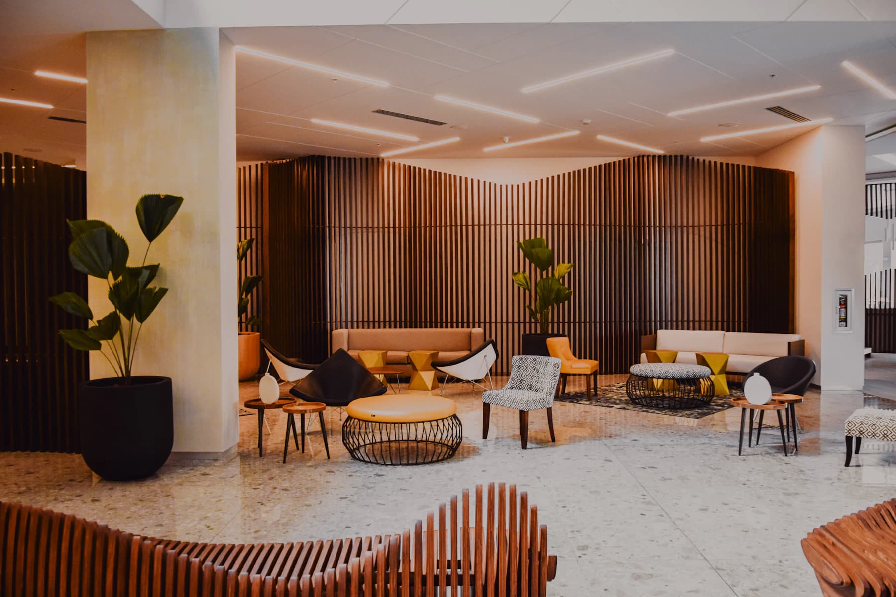 Modern hotel lobby with warm wood walls and designer seating
