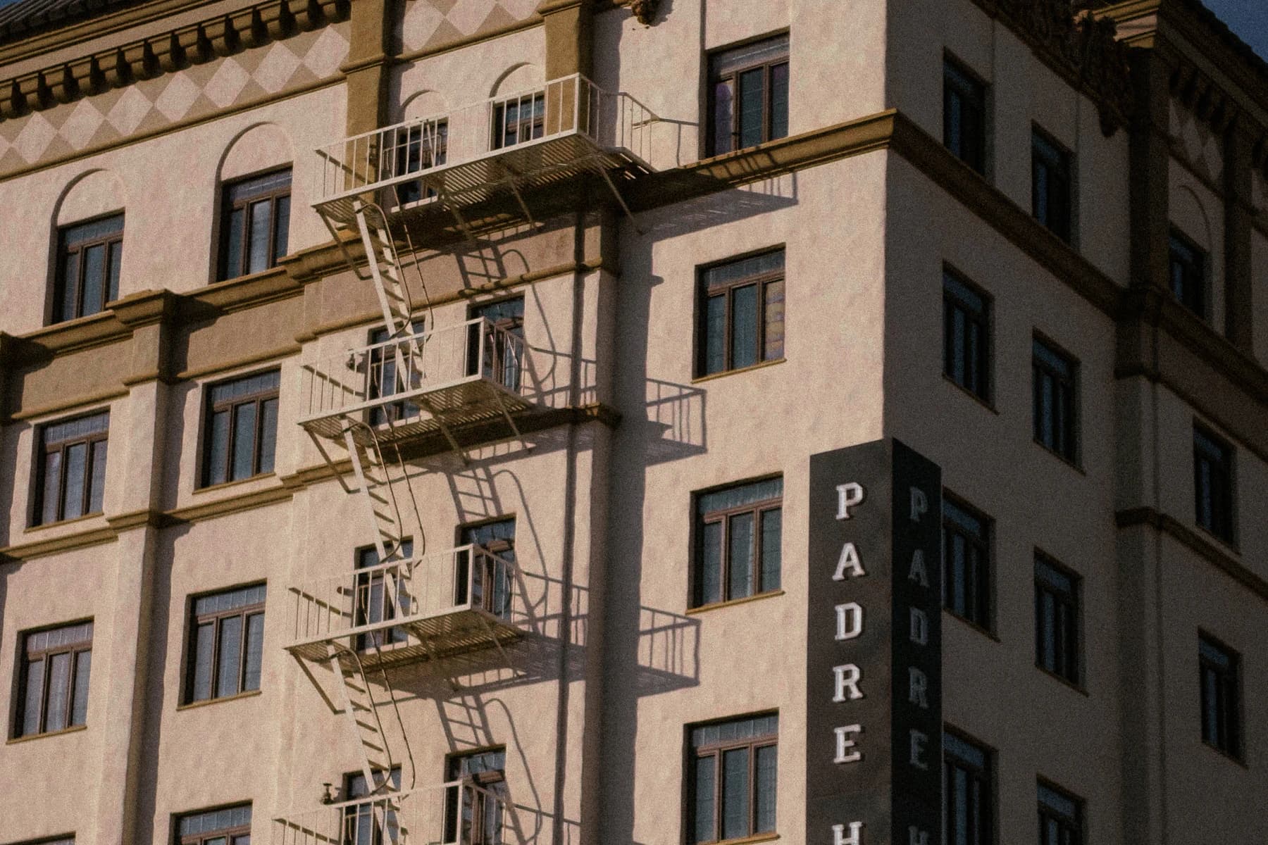 Sunlit urban hotel facade with exterior fire escapes