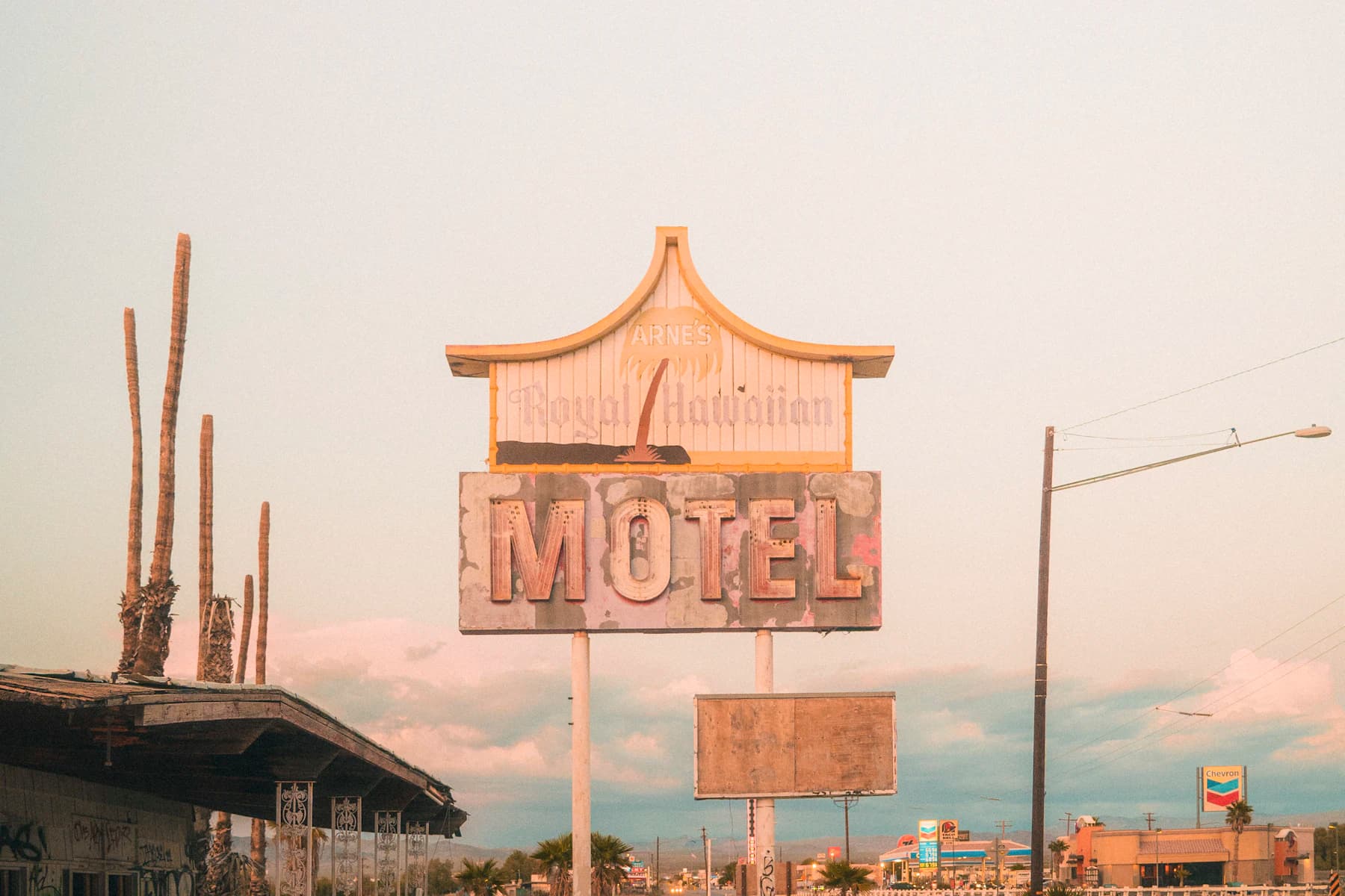 A vintage motel sign beside a desert road